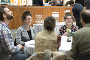 A student and two donor representatives laugh at a table