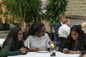 Three attendees laughing at table