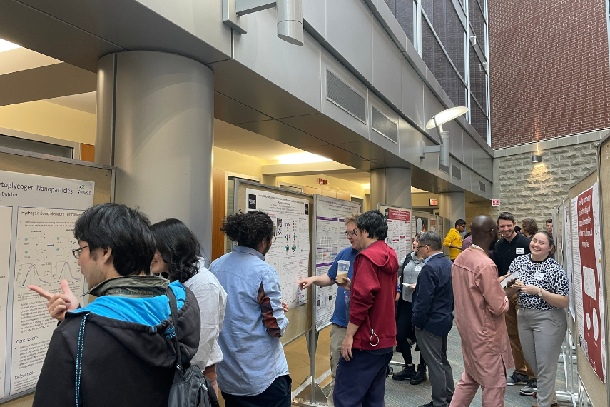 Students talking and presenting to attendees and judges, multiple posters in view.