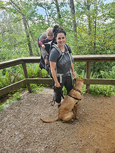 Carly walking with her child and dog in scenic area