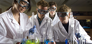 Students looking at beakers on counter