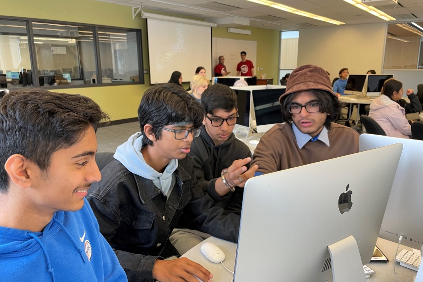 4 students work together on a computer