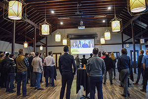 Wide-angle shot of attendees watching presentation