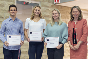 Three students stand with the dean of CEPS with their awards