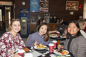 Group of three women attendees smiling at the camera.