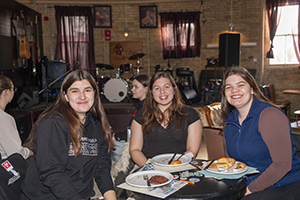 Group of three women attendees smiling at the camera.