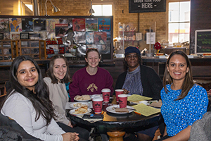 Group of attendees at breakfast smiling at the camera.