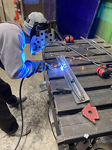 Person welding metal with a mask on.