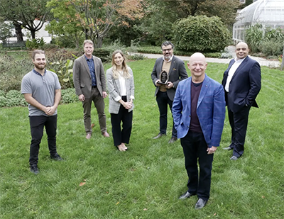 Image of Wael Ahmed and team, along with Research Innovation Office team members, with their prize on campus.