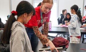 U of G student volunteer helping student with activity.