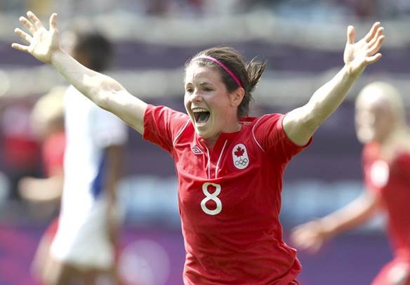 Diana Matheson celebrates on the soccer field wearing a red Canadian jersey