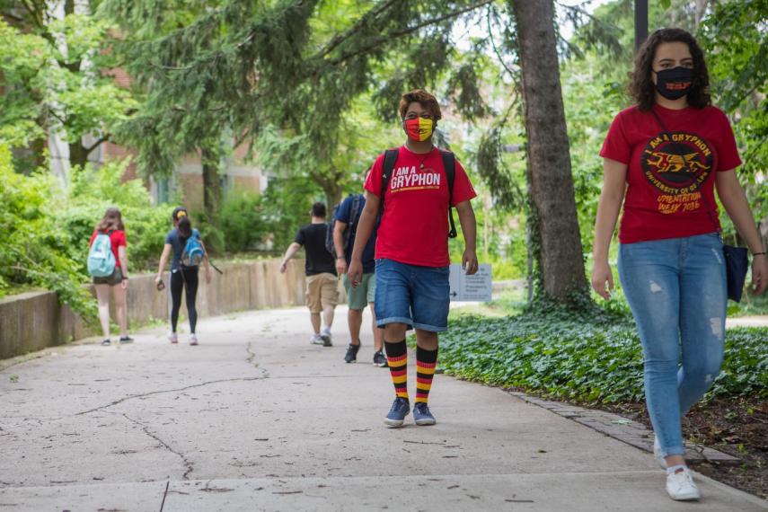 Image of students walking on campus wearing U of G gear and masks while physical distancing