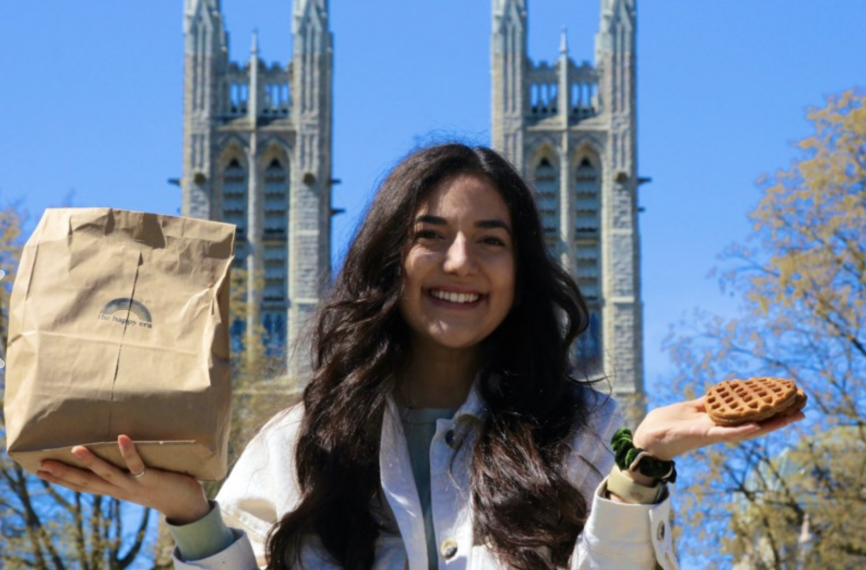 Domenique Mastronardi holding her waffle creation while standing in front of the Basilica of Our Lady Immaculate in downtown Guelph