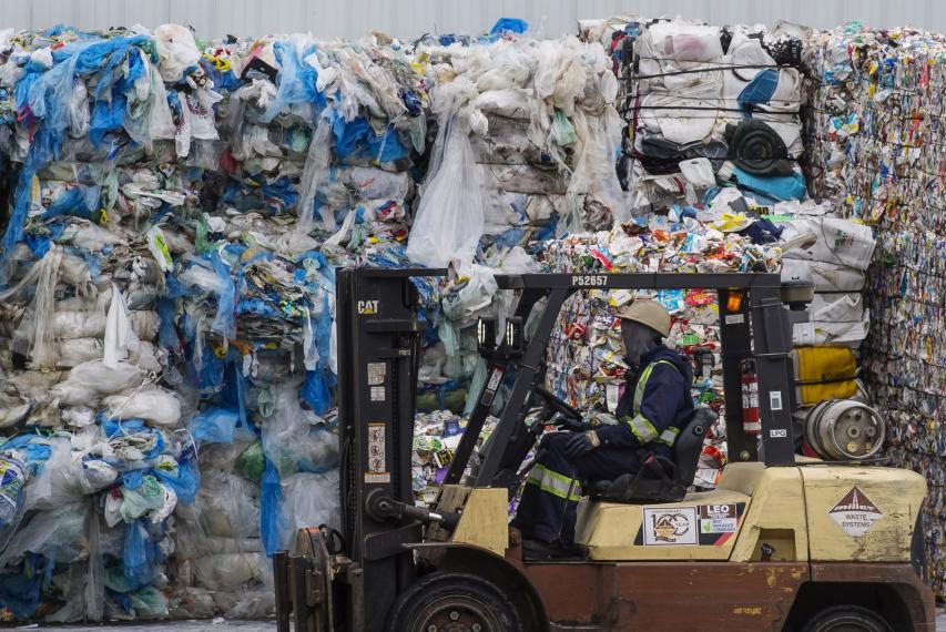 Image of plastic waste pile with forklift in front