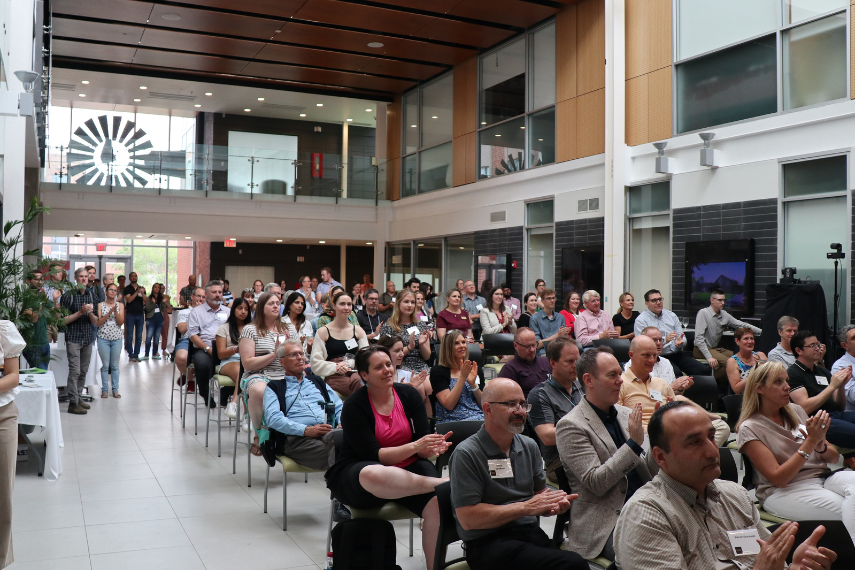 A crowd looks on at the presentation inside the Thornbrough Atrium
