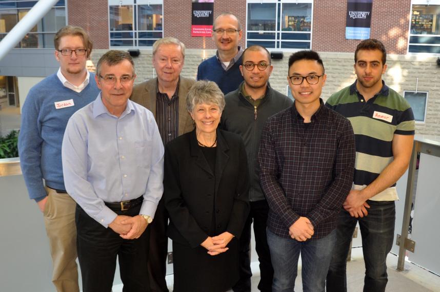 Bob and Nancy Burnside standing with students and Dean inside an atrium