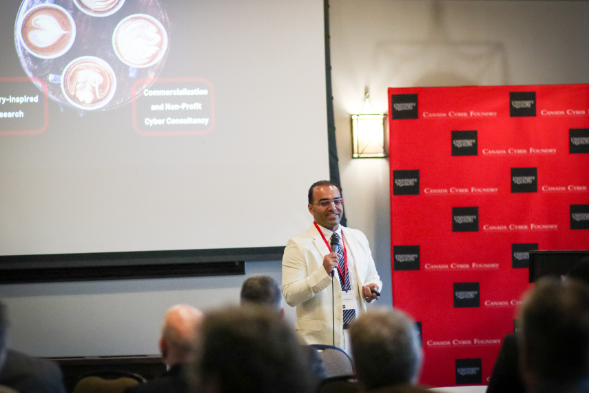 Man talking in white suit in front of tables of people