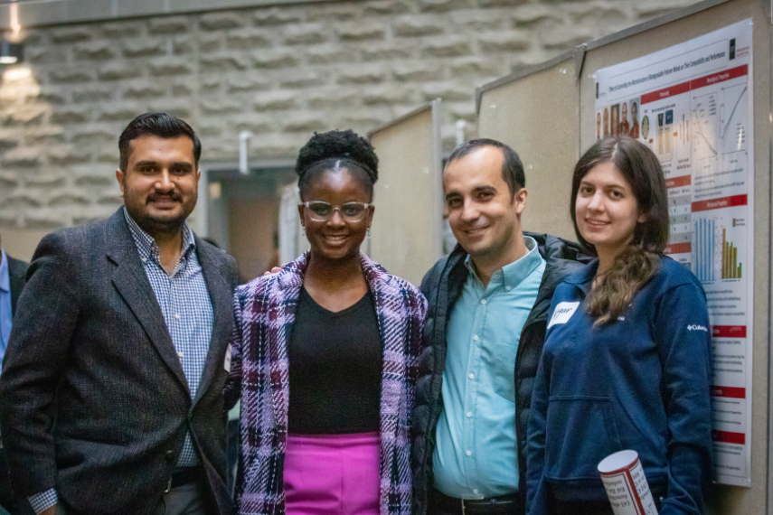 Phd students and faculty member stand smiling 