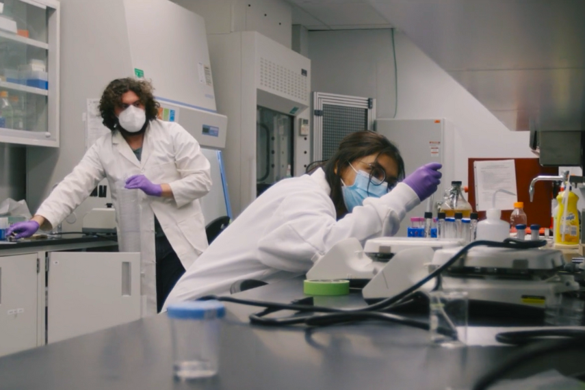 Two students in a lab working with equipment