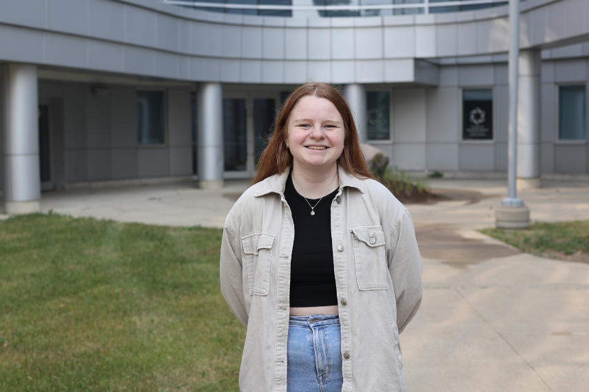 Female student standing outside in front of building 