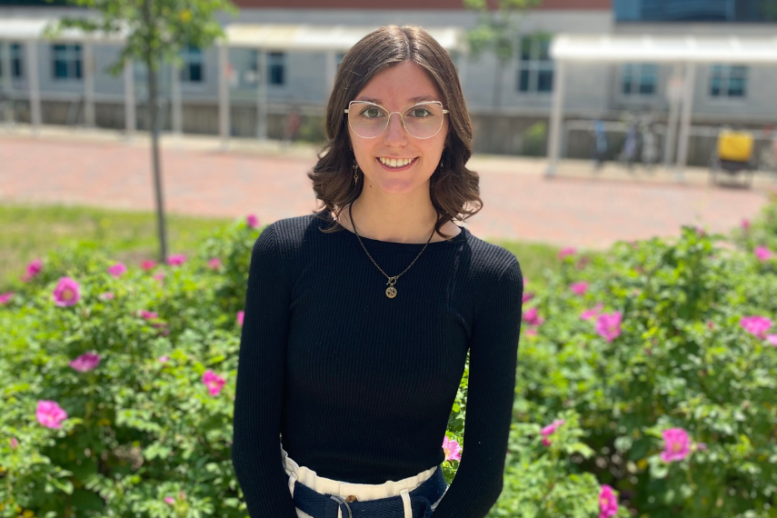 Picture of Laney Beausoleil in front of an colourful flowery plant