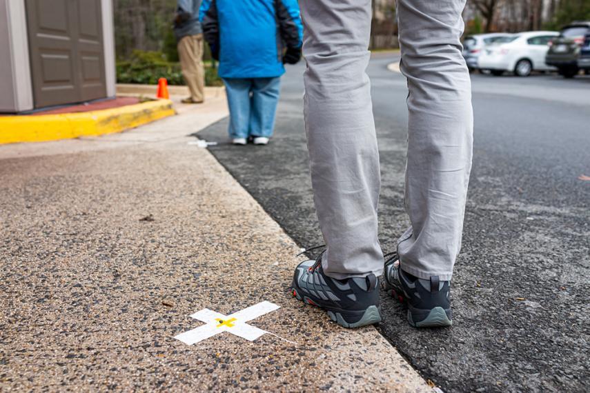 Image of person standing next to "X" on pavement with another person far ahead of them