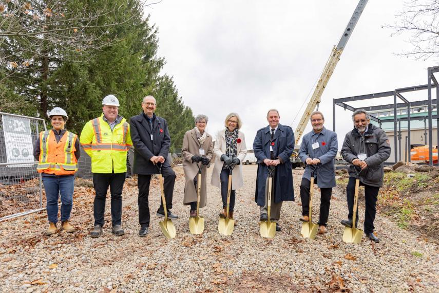 People standing with gold shovels at construction site