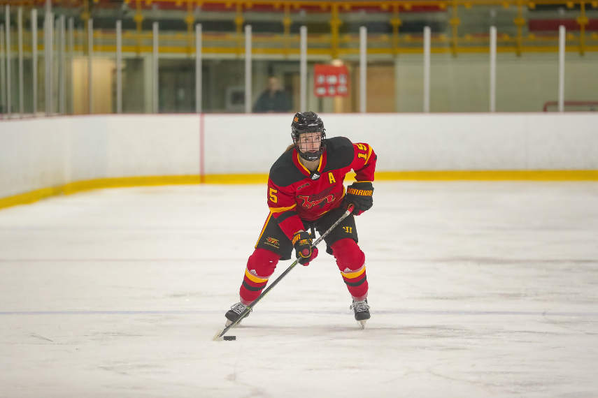 Rylee Davison stick handles the puck wearing U of G jersey on ice rink