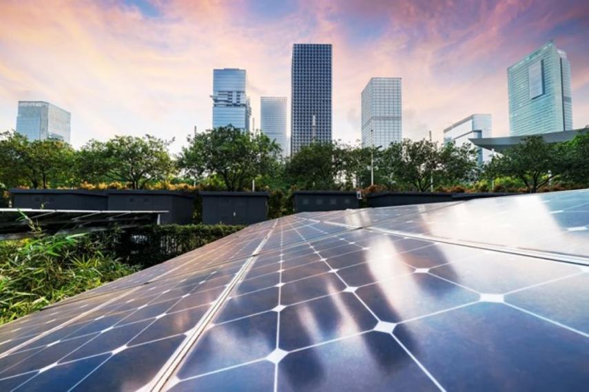 Image of modern, futuristic cityscape with greenery and sunset in background