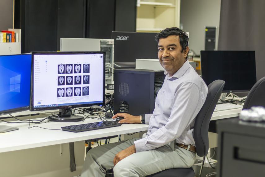 Dr. Eranga Ukwatta in his University of Guelph lab space with article research on screens