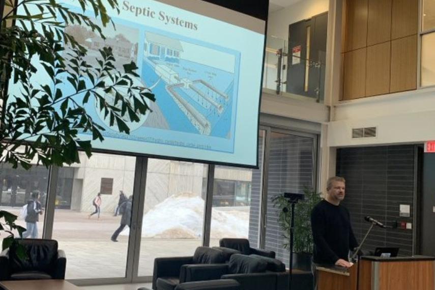 A man presents on a projector about septic systems