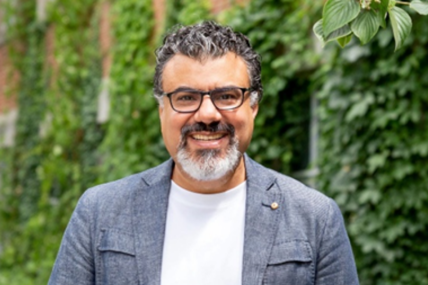 Headshot of Dr. Wael Ahmed outside of greenery covered building