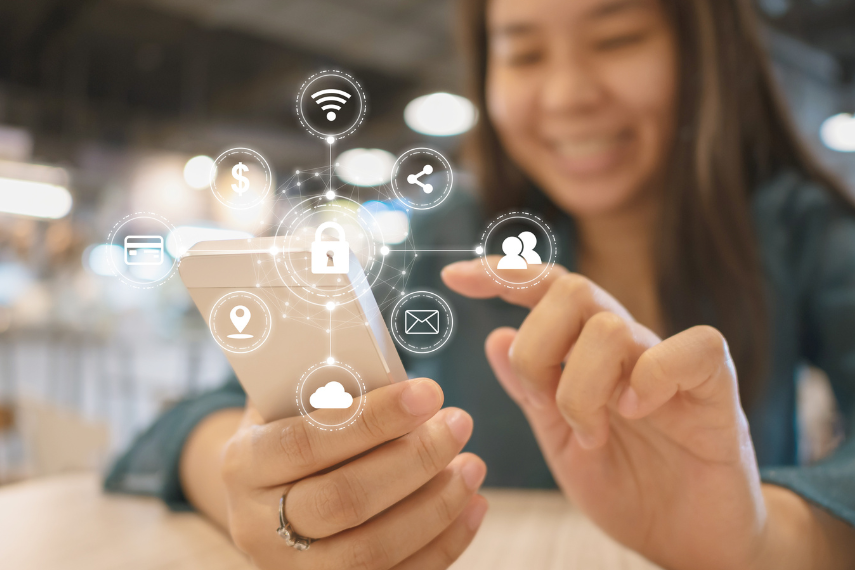 Stock image of student blurred in background playing on phone with stem symbols in focus in front of her. 