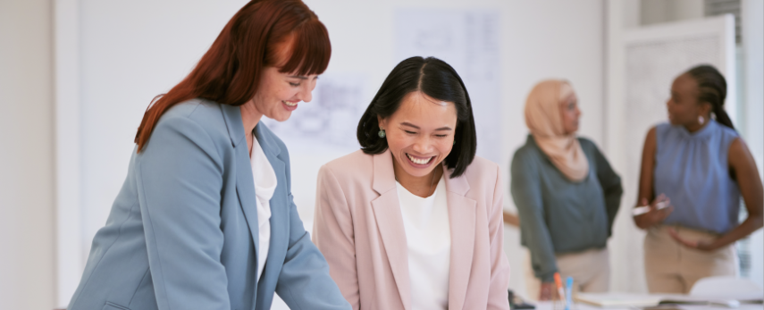 Women standing in an office working over a table