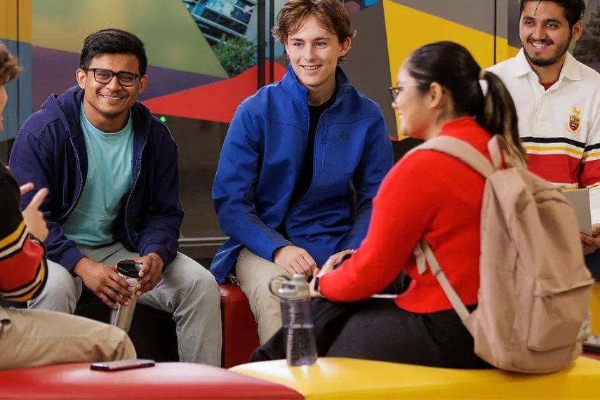 group of diverse students sitting down chatting.