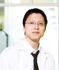 Headshot of Alexander Wong looking at the camera in a white button up shirt with a black tie