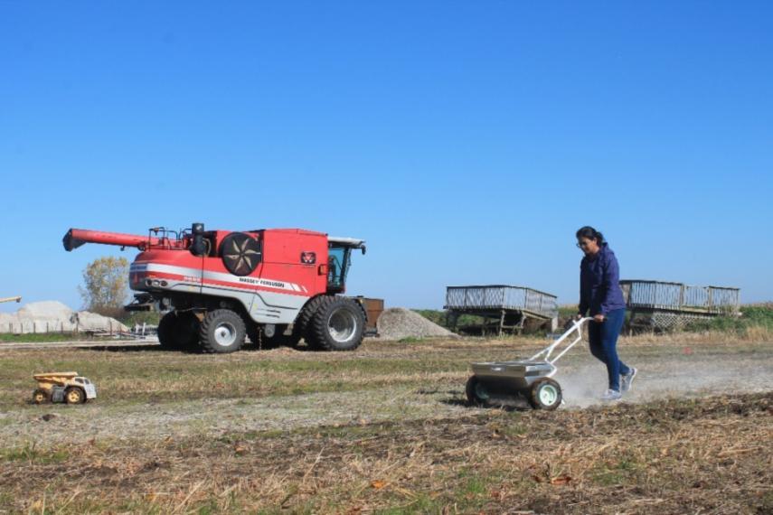 A person operates farming machinery on a farm