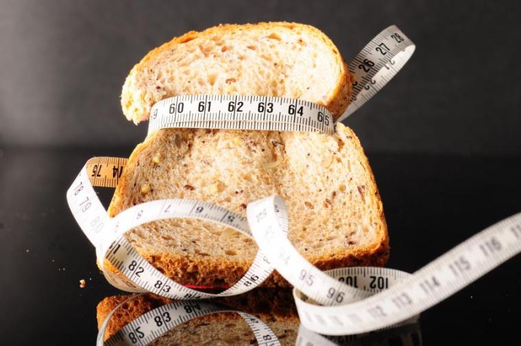 Slice of bread with measuring tape wrapped around it