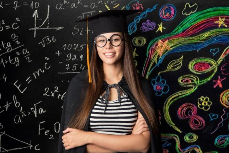 Girl standing in front of a blackboard with equations on her right and creative colourful drawings on her left
