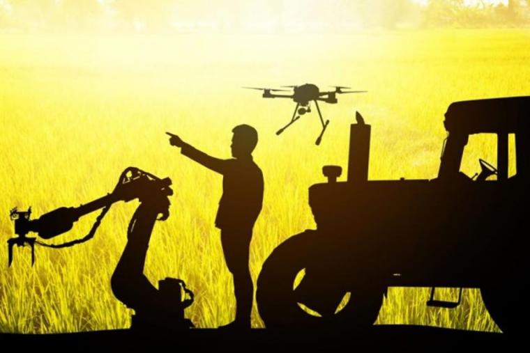 Silhouette image of a person and robotic equipment on a farm including a drone and a tractor