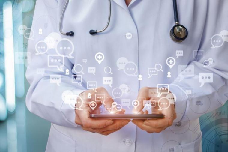Composite image of person holding iPad in doctor's uniform with data emitting from screen