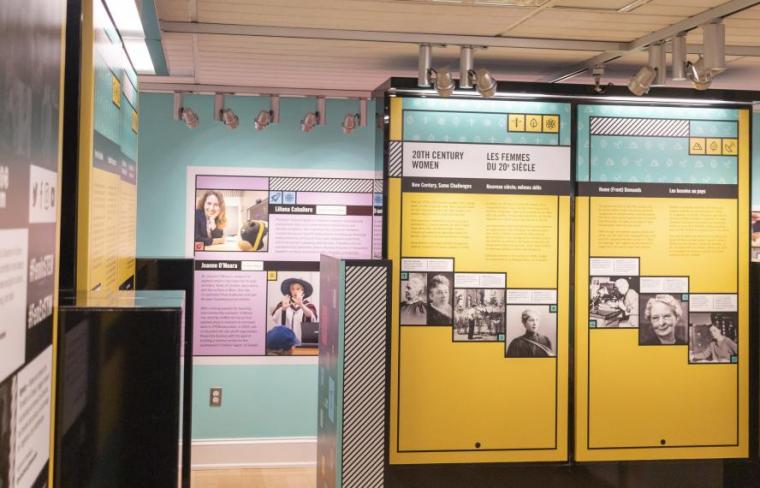 View looking at one element of Iron Willed exhibition, showing several columns with information from the national exhibition as well as a glimpse of local physics researchers from the university of guelph