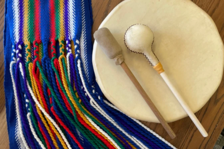 Blue, white, red, yellow and green beads next to a drum.