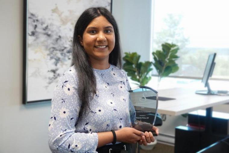 Image of Amanda Pinto in an office, smiling at the camera. 