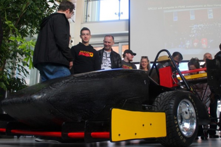 GryphRacing car with team members in the background. 