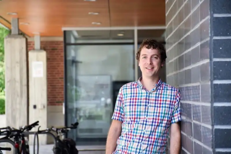 Professor Graham Taylor leaning against a wall, smiling at the camera. 