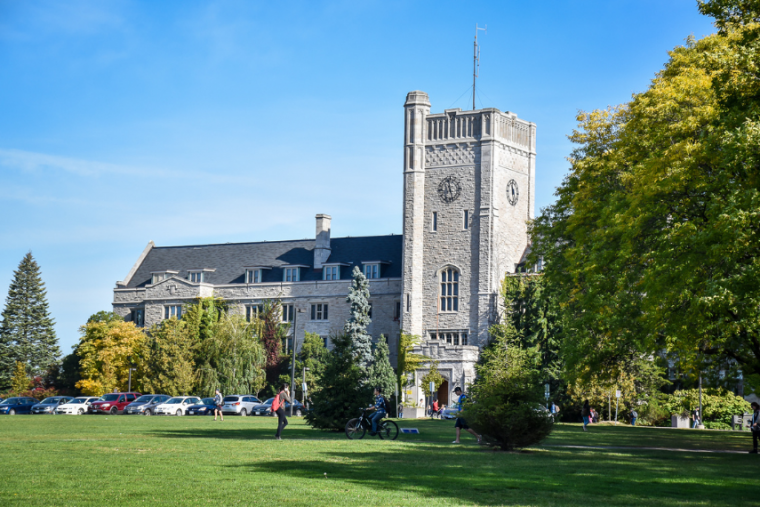 Johnston Hall during the summer on campus, surrounded by trees. 