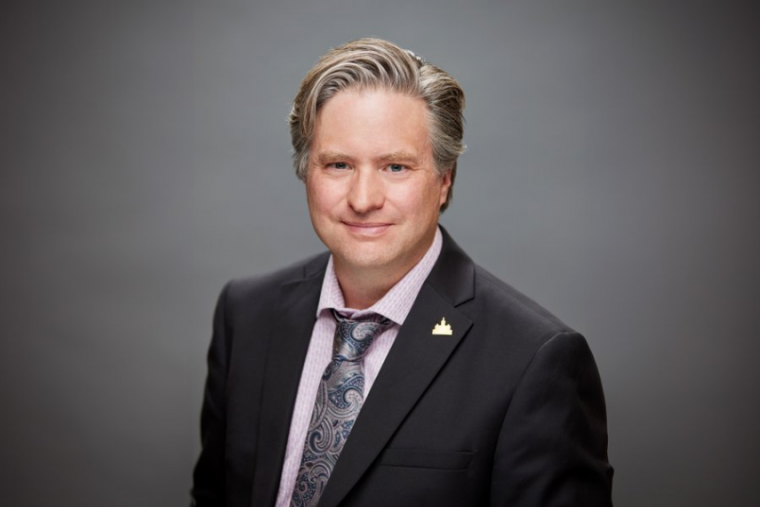 Dr. Bill Rosehart smiling at the camera, wearing a suit. 
