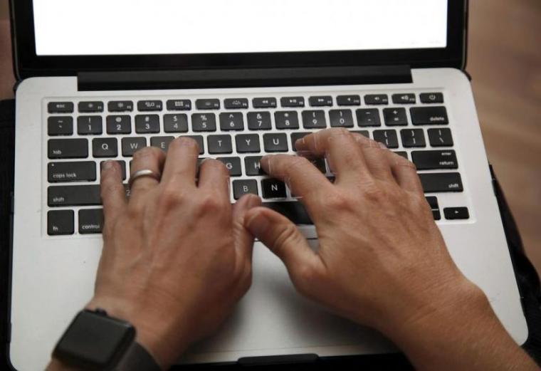 A person typing on a laptop.