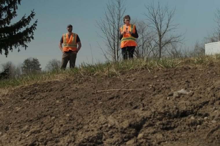 Dr. Beth Parker and another researcher stand outside in field